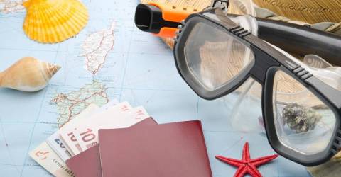 Duikbril met paspoort op landkaart